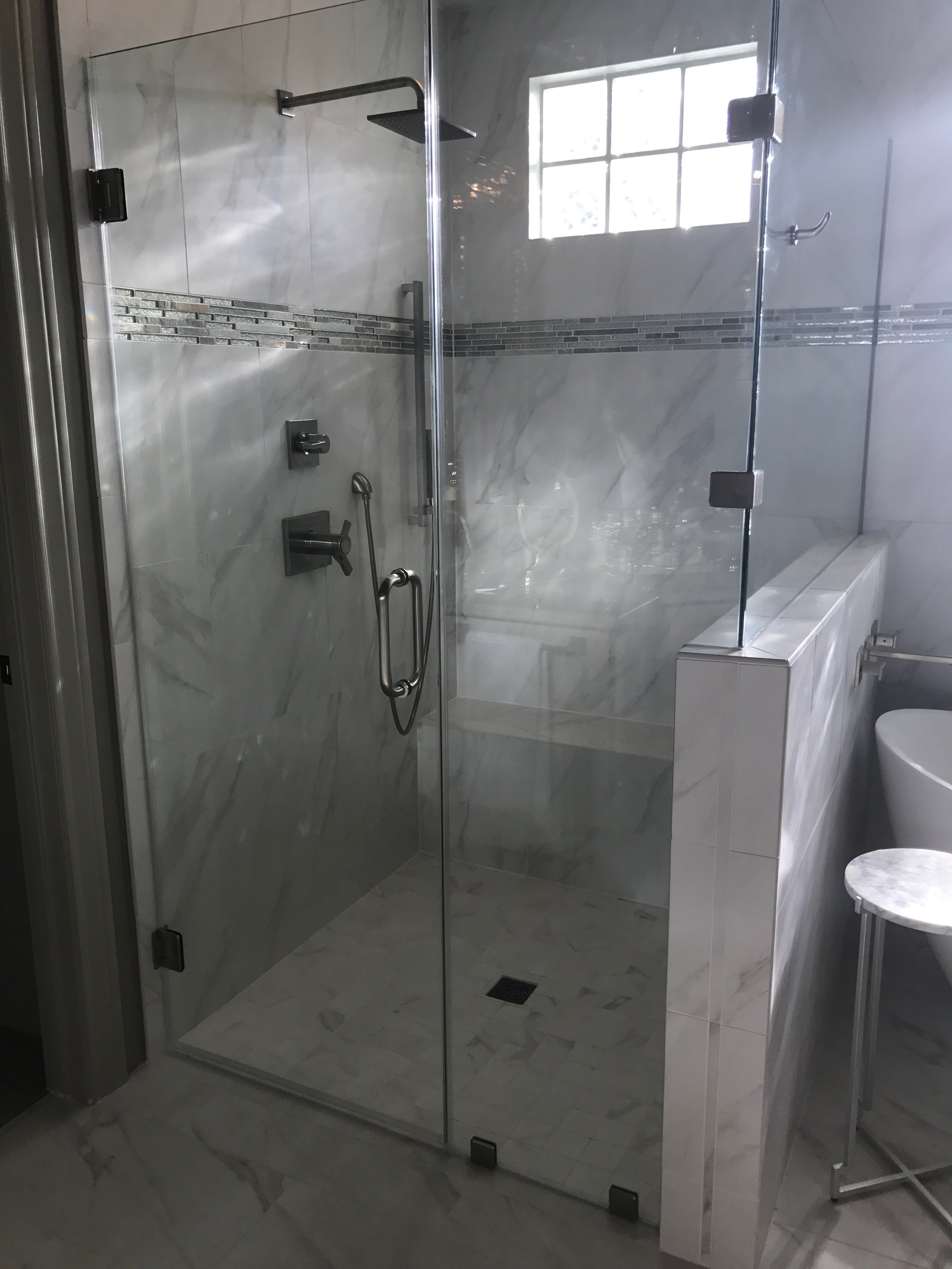 Beautiful tile shower, and glass doors.