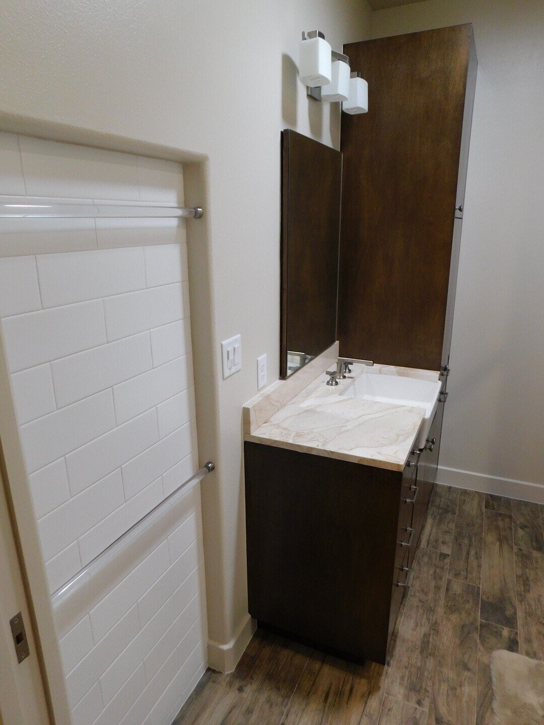 Secondary bath remodel near the Woodlands - European style vanity, towel niche, farm sink, wood-look floor &amp; subway shower tile