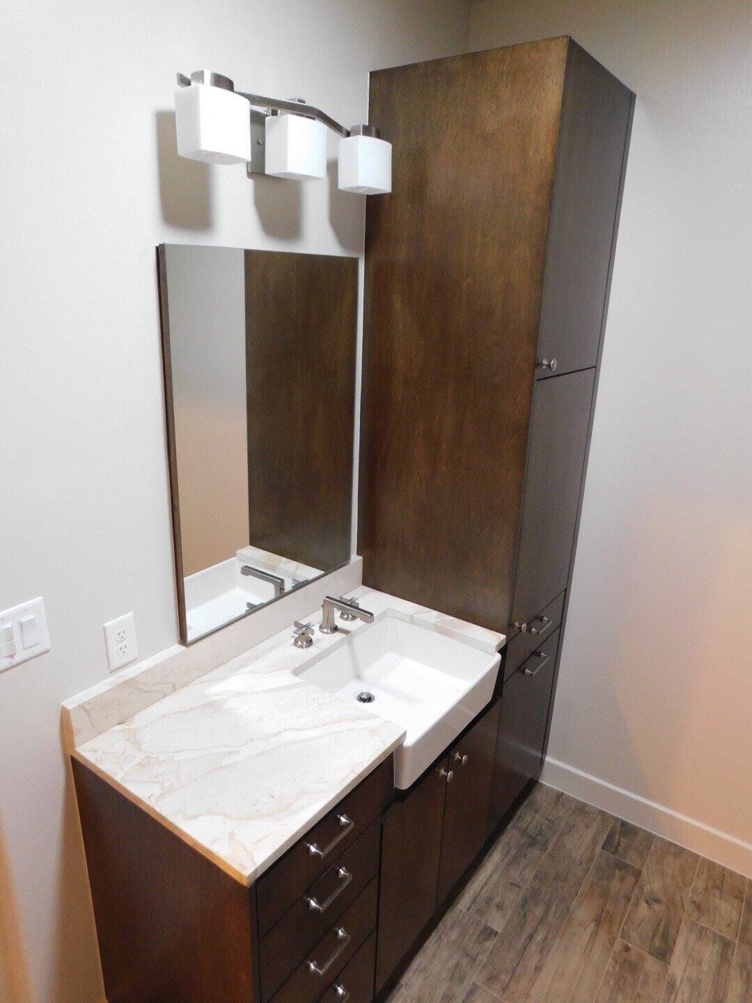 Bathroom Remodel in Conroe - European style cabinets with build-in medicine cabinet. Wood-look tile floor