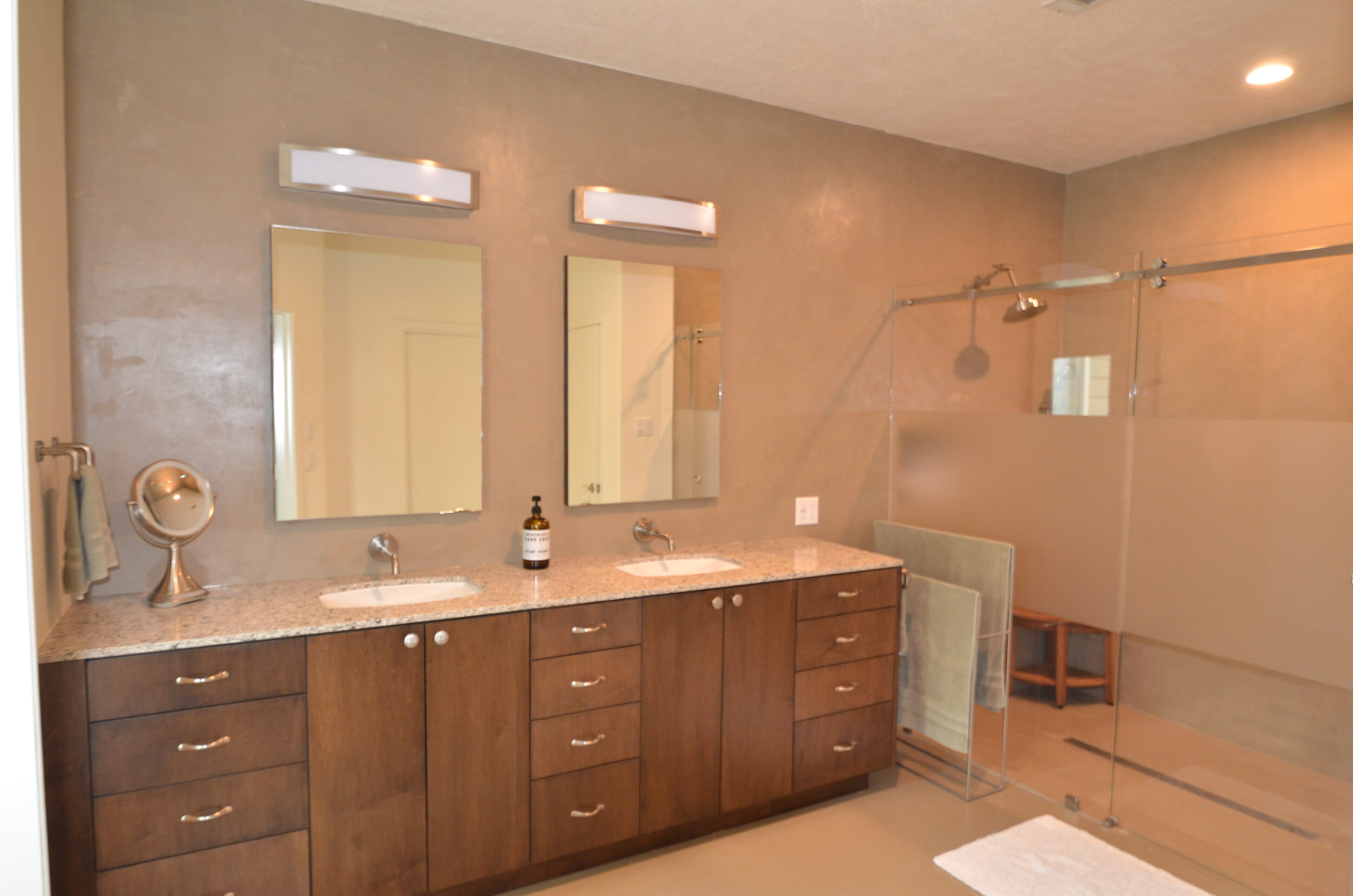 Master Bath - Stained Euro-style vanity cabinet, his &amp; her recessed medicine cabinets with glass shelving, wall mounted faucets, and countertop with undermount sinks 